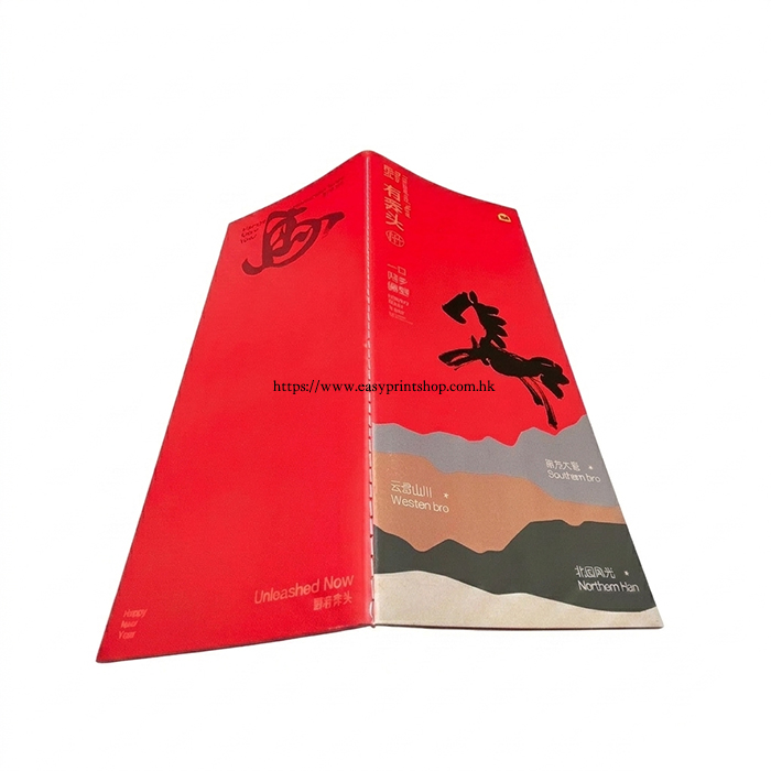 An angled view of the brochure's exterior, featuring a vibrant red cover with a prominent black horse silhouette graphic and mountain-themed print design An-angled-view-of-the-brochures-exterior-featuring-a-vibrant-red-cover-with-a-prominent-black-horse-silhouette-graphic-and-mountain-themed-print-design